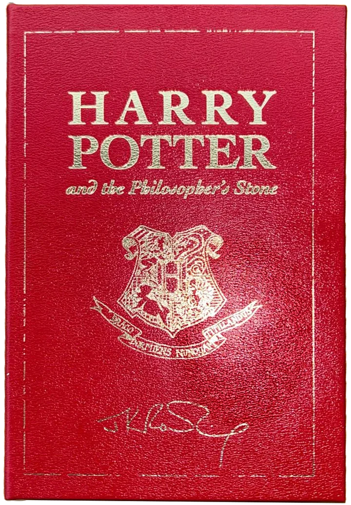 Front cover: red leather binding with gold-embossed title, Hogwarts crest and J.K. Rowling's signature